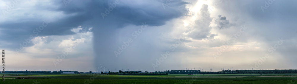 Dramatic skies with thunderstorms are moving across the flat landscape of the island of Flakkee, The Netherlands