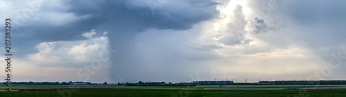 Dramatic skies with thunderstorms are moving across the flat landscape of the island of Flakkee, The Netherlands