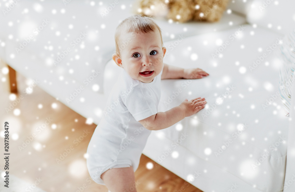 childhood, babyhood, emotions and people concept - happy little baby boy or girl at home over snow childhood, babyhood, emotions and people concept - happy little baby boy or girl at home over snow