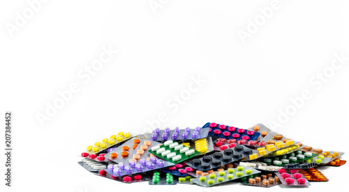 Pile of tablet pills isolated on white background. Yellow, purple, black, orange, pink , green tablet pills in blister pack. Painkiller medicine. Drug for migraine headache. Pharmaceutical industry.