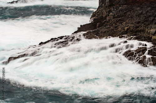 The wild Atlantic Ocean crashes against the rocks along the Western shore of Shetland Islands at Eshaness