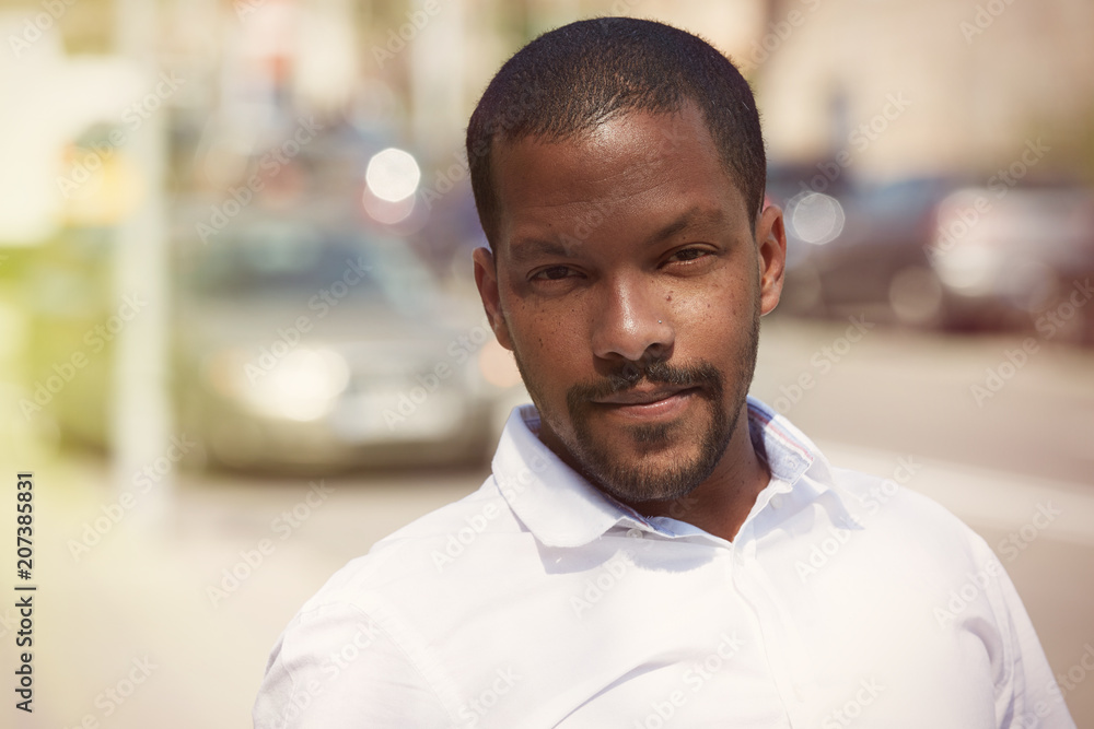 Portrait of happy confident young African-American businessman in formal wear on blurred background Portrait of happy confident young African-American businessman in formal wear on blurred background