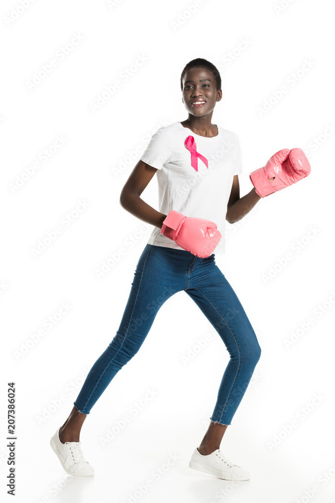 beautiful african american girl with pink ribbon boxing and smiling at camera isolated on white, breast cancer concept beautiful african american girl with pink ribbon boxing and smiling at camera isolated on white, breast cancer concept