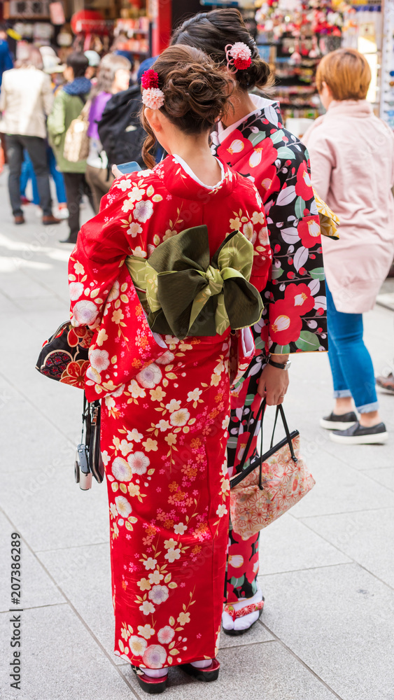 Naklejka premium TOKYO, JAPAN - OCTOBER 31, 2017: The girl in a kimono on a city street. Copy space for text. Vertical.