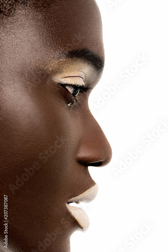 profile portrait of beautiful tender african american girl with white makeup looking away isolated on white