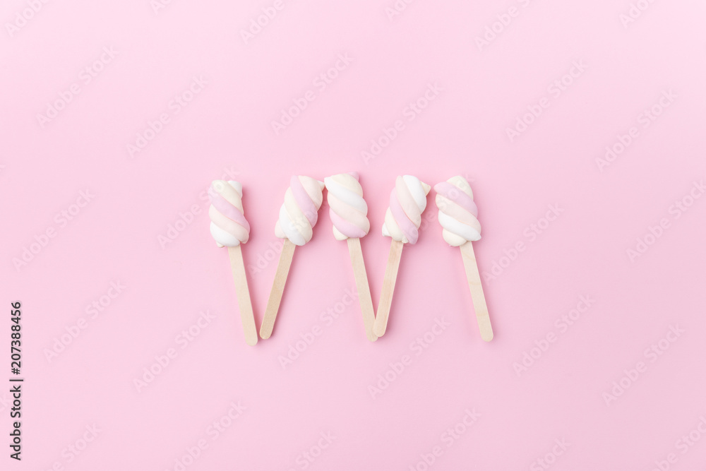 Marshmallows on sticks on tender pink background Marshmallows on sticks on tender pink background