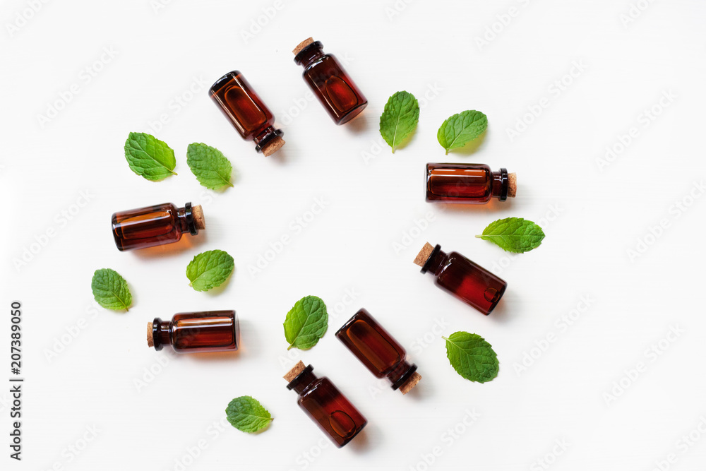 Essential oil with fresh mint leaves on white background. Essential oil with fresh mint leaves on white background.