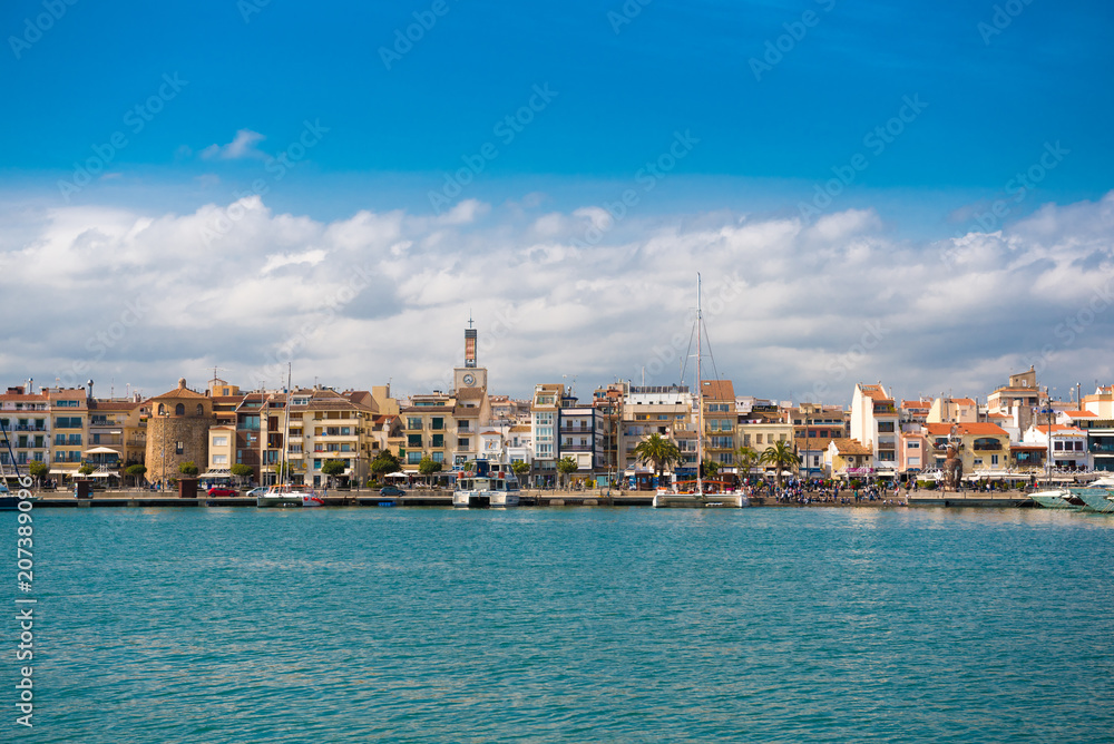 CAMBRILS, SPAIN - APRIL 30, 2017: View of port and city waterfront with Church Of Saint Peter in middle and Torre del Port. Copy space. Copy space for text.