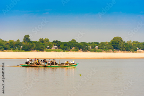 MANDALAY, MYANMAR - DECEMBER 1, 2016: People in a boat on the Irrawaddy river. Copy space for text. photo