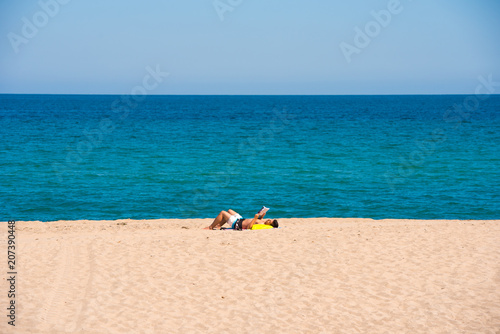 MIAMI PLATJA, SPAIN - APRIL 24, 2017: The man on the beach sunning. Copy space for text.