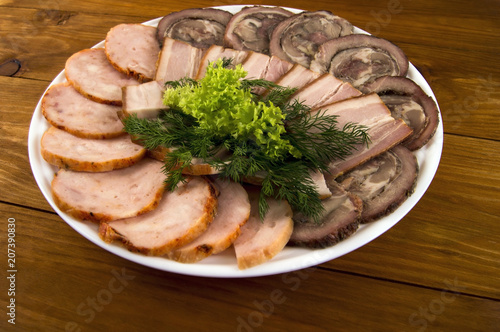 Bacon, roll and sausage, decorated with salad and dill on a wooden background