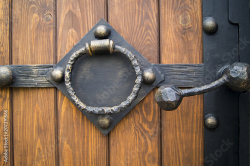 Fotografie decorative frame with handles in the shape of a ring on a wooden gate background