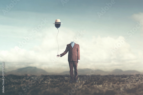 man without head holds black balloon with hat surreal concept photo