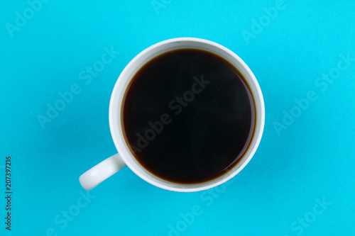 Black coffee in white cup on blue blackground pastel style copyspace flatlay