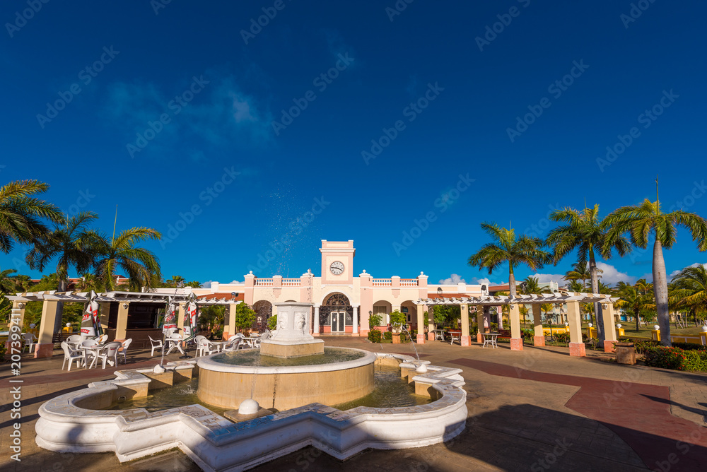 VARADERO, MATANZAS, CUBA - MAY 18, 2017: View of the fountain and the building. Copy space for text. Isolated on blue background.