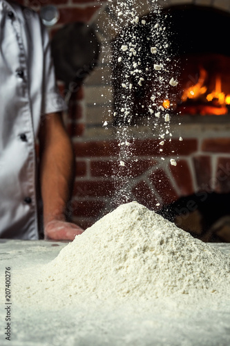 chef making dough for pizza. Man hands preparing bread. Concept of baking and patisserie