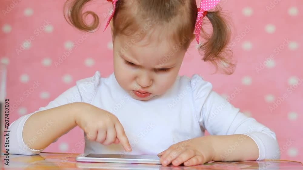 Child playing with a mobile phone. Child playing with a mobile phone.