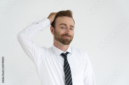 Grinning conceited businessman self satisfied. Young man in tie and white shirt touching hair with vain face. Vanity and ambition concept