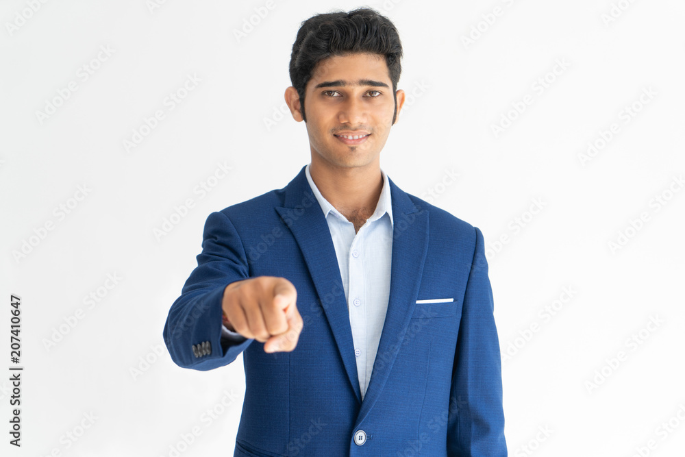 Portrait of happy manager pointing at camera with forefinger. Young Indian businessman wearing blue jacket making choice. Recruitment concept Portrait of happy manager pointing at camera with forefinger. Young Indian businessman wearing blue jacket making choice. Recruitment concept