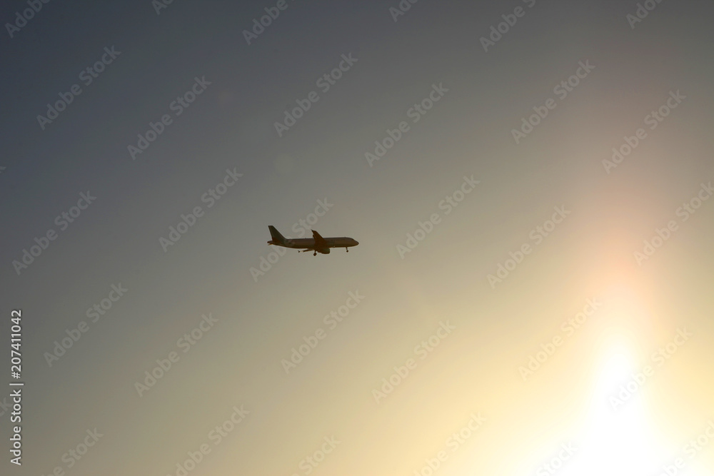 Passenger plane in the sky at sunrise or sunset. Vacation and travel concept. Toned image