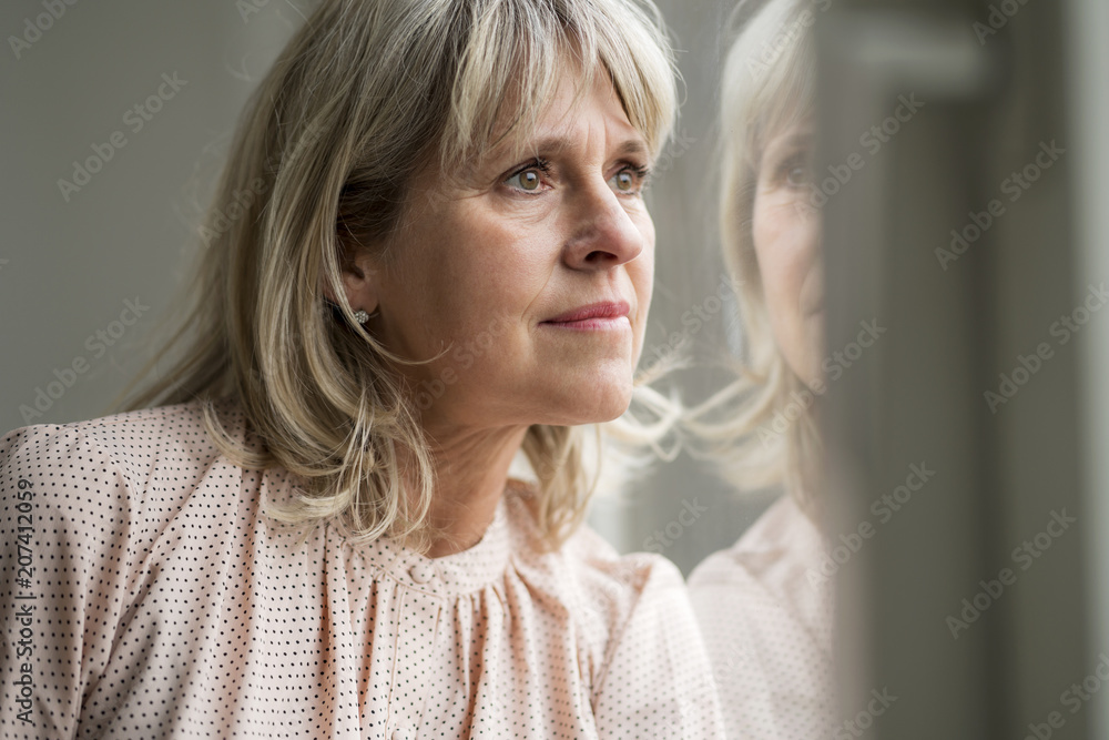 Mature woman looking out of window Mature woman looking out of window