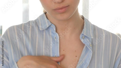Crop close-up view of woman passing hand over breast in unbuttoned shirt