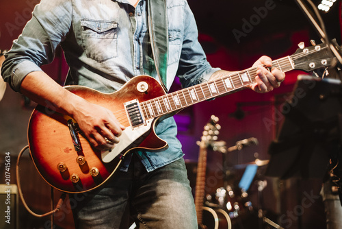 attractive man playing electric guitar
