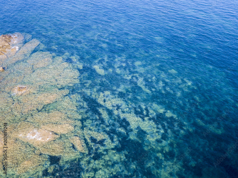 Vista aerea di scogli sul mare. Panoramica del fondo marino visto dall’alto, acqua trasparente