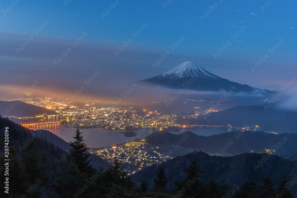 Night landscape of Mountain Fuji with cloudy sky and Kawaguchiko lake seen from Shindo toge view point.