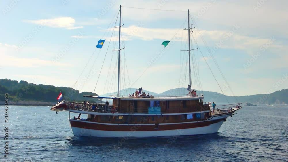 A large sailboat with tourists sails off the coast of Croatia A large sailboat with tourists sails off the coast of Croatia