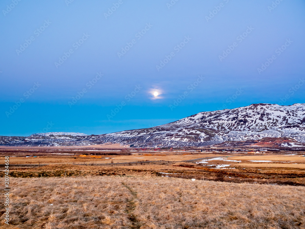 Mountain and field under full moon in Iceland