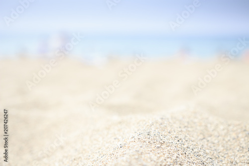 Blurred beach background with white sand  blue sea and sky on horizon. Sandy beach.