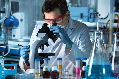 Obraz na plátně microscopist analyzing samples in the microscope / microbiologist working with s