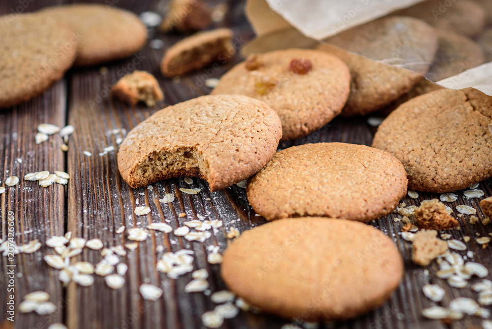 Homemade oatmeal cookies with raisins, cinnamon with milk on dark wooden background. Homemade oatmeal cookies with raisins, cinnamon with milk on dark wooden background.