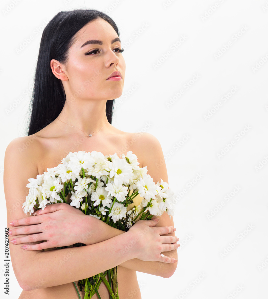 Girl on calm face naked holds chamomile flowers in front of breasts. Woman with smooth healthy skin looks attractive. Lady covers breasts with flowers, isolated on white. Natural cosmetics concept. Girl on calm face naked holds chamomile flowers in front of breasts. Woman with smooth healthy skin looks attractive. Lady covers breasts with flowers, isolated on white. Natural cosmetics concept.
