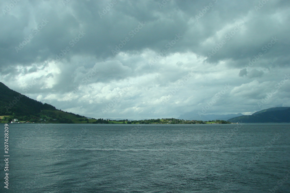 Sea landscape near the coast of Norway on the background of the cloudy northern Scandinavian sky.