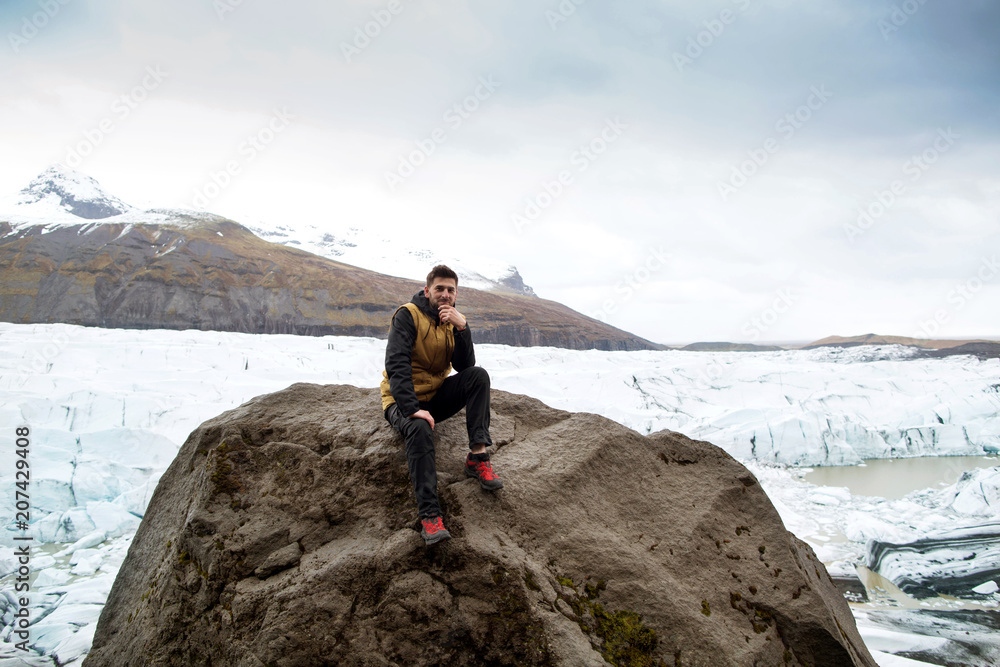 Obraz premium tourist sits near the glacier iceberg in Iceland