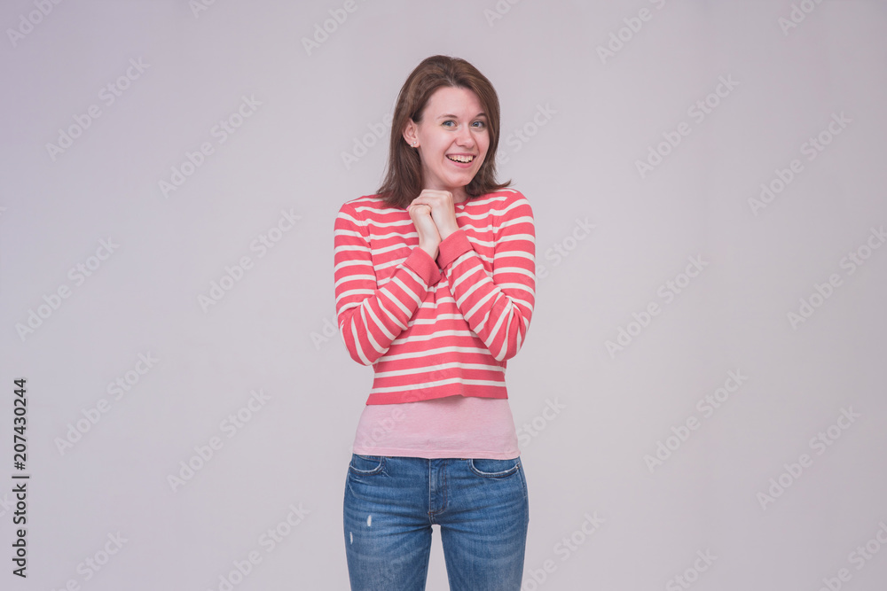 portrait of a beautiful brunette girl in jeans on a white background in different poses with different emotions. portrait of a beautiful brunette girl in jeans on a white background in different poses with different emotions.