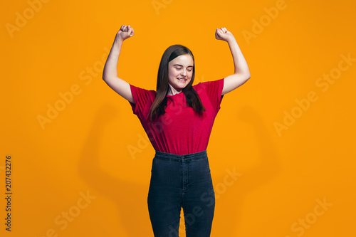 Happy success teen girl celebrating being a winner. Dynamic energetic image of female model