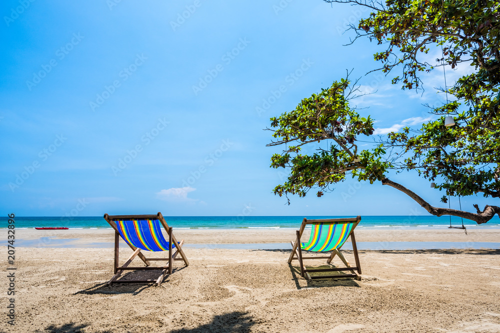 Tropical tree and beach chair at white sand beach and blue sea Tropical tree and beach chair at white sand beach and blue sea