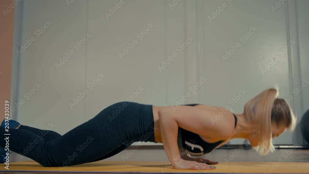 Blond Sporty Caucasian Lady is Doing Push Ups in the Gym during Training Blond Sporty Caucasian Lady is Doing Push Ups in the Gym during Training