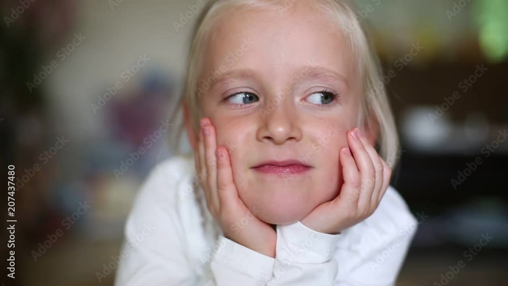 Close up face of cute little girl looking at the camera and blinking Close up face of cute little girl looking at the camera and blinking