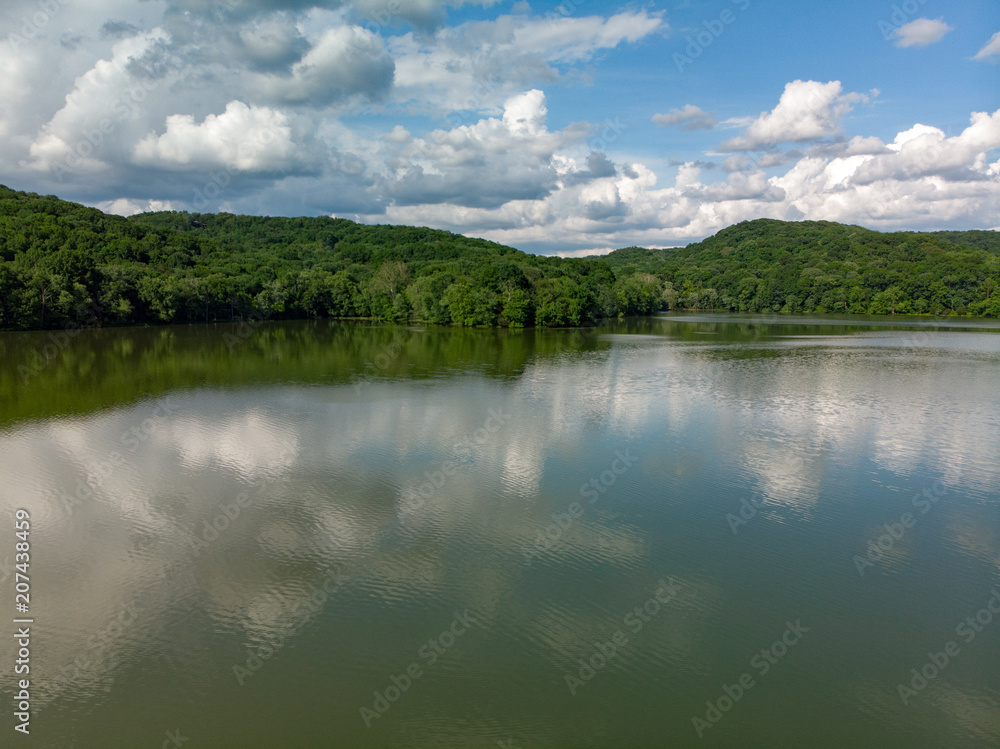 Aerial Forest Mountains On Reflective Lake with Cloudy Sky