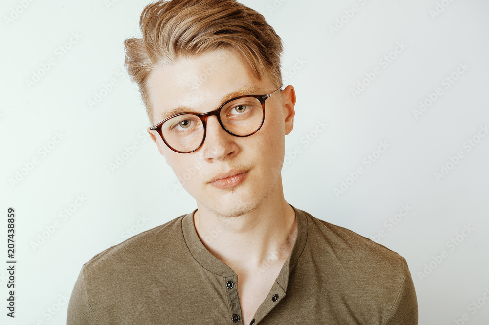 close up portrait of young blonde man wearing eyeglasses and looking confident at camera