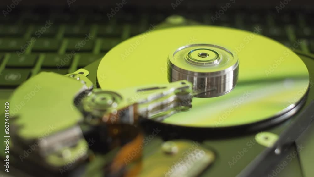 Disassembled computer hard drive disk. Green reflections on plates. Disassembled computer hard drive disk. Green reflections on plates.
