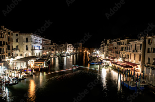 A late night long exposure view of the popular Grand Canal in Venice, taken from the top of the Ponte Rialto Bridge, with a light trail set provided by a boat manoeuvring in the moorings. © Oliver