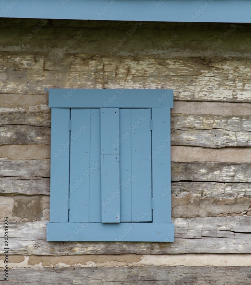 The old blue window frame on the side of the cabin. The old blue window frame on the side of the cabin.