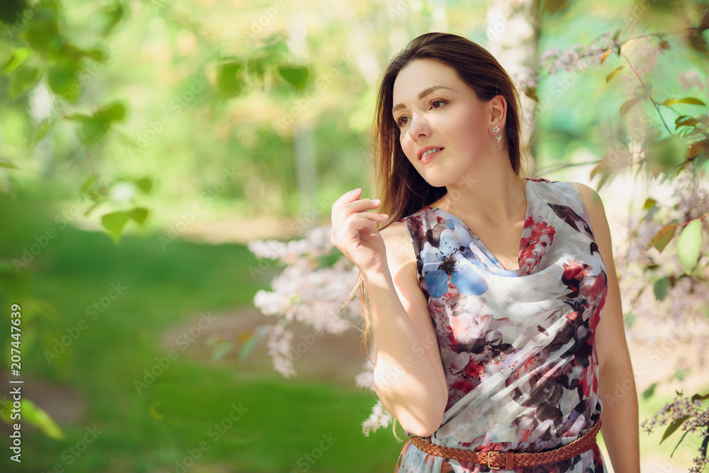 Young woman enjoying spring in the green field with blooming trees Young woman enjoying spring in the green field with blooming trees