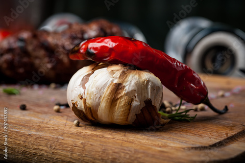 grilled chili pepper with garlic on a wooden board