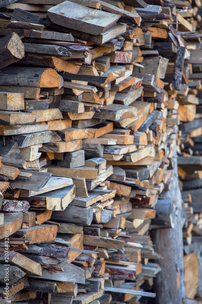Pile of chopped fire wood prepared for winter. Stack of chopped firewood prepared winter. Stocking up of firewood. Firewood background - chopped firewood on a stack. Selective focus on a foreground.